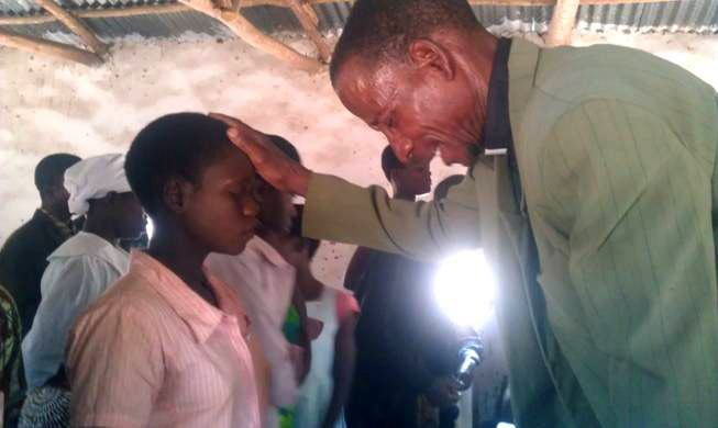 Overseer Moyenda praying for the sick